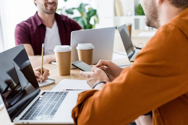 Imagem cortada de colegas que trabalham no projeto de inicialização no escritório com laptops e discutir algo — Fotografia de Stock