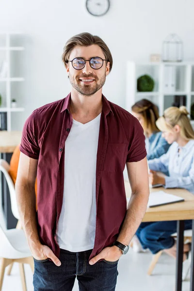 Handsome man standing in office of startup project and looking at camera — Stock Photo