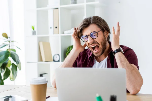 Schöner Geschäftsmann schreit, während er im Büro an einem Startup-Projekt arbeitet — Stockfoto