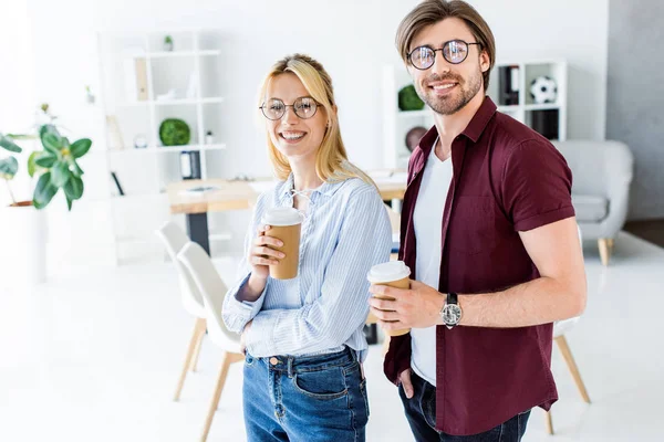 Colleagues of startup project holding disposable coffee cups in office — Stock Photo