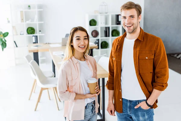 Multicultural colleagues of startup project looking at camera in office — Stock Photo