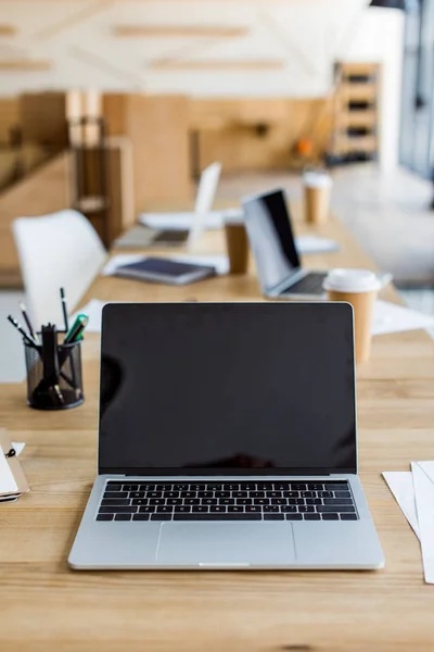 Ordinateur portable avec écran blanc sur la table dans le bureau d'affaires — Photo de stock