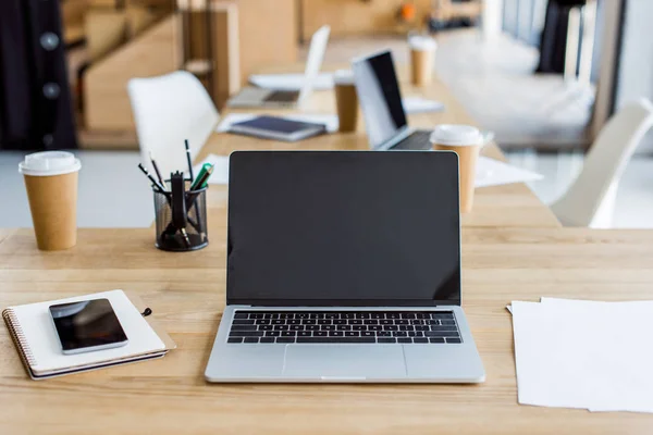 Laptops und Smartphones auf Tischen im Büro — Stockfoto