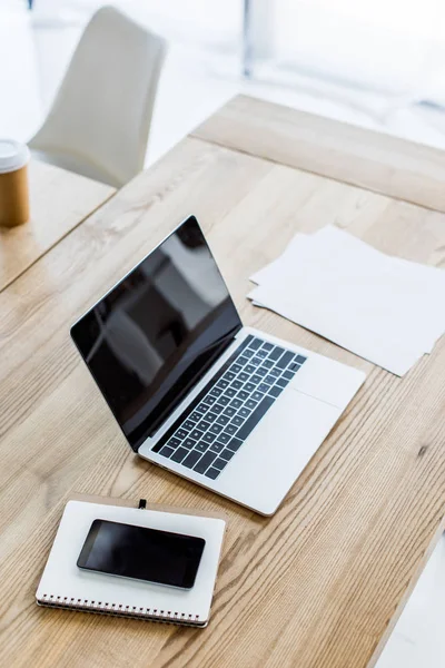 High angle view of laptop, smartphone and notebook on table in business office — Stock Photo