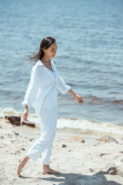 Alto ángulo vista de hermosa mujer asiática de pie en la playa por el mar - foto de stock