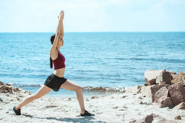 Giovane sportiva asiatica che esercita sulla spiaggia di fronte al mare — Foto stock