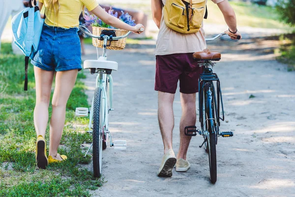 Partial view of couple with backpacks and bicycles in park — Stock Photo