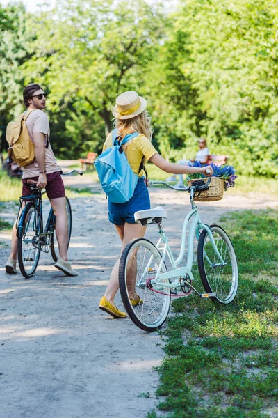 Vista trasera de la pareja con bicicleta retro en el parque en el día de verano - foto de stock