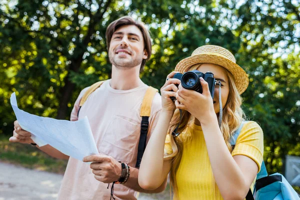 Портрет пары туристов с картой и фотокамерой в парке — стоковое фото