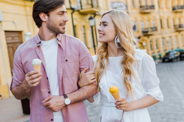 Portrait de jeune couple avec crème glacée marchant dans la rue le jour d'été — Photo de stock