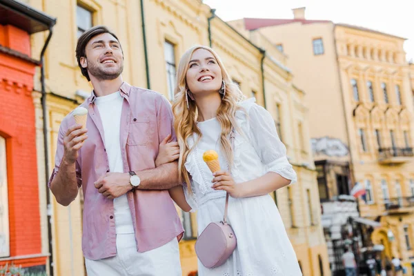 Портрет молодой пары с мороженым, гуляющей по улице в летний день — стоковое фото