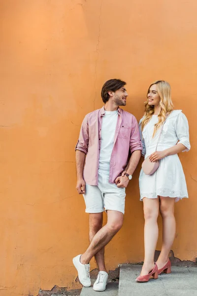 Giovane coppia elegante in piedi contro muro edificio della città — Foto stock