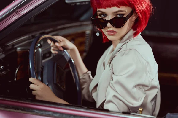 Красивая стильная девушка в солнечных очках за рулем ретро автомобиля — стоковое фото