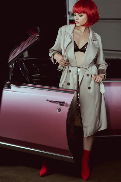 Fille élégante en soutien-gorge et trench coat debout près de voiture rétro — Photo de stock