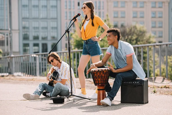 Team di giovani amici che si esibiscono e cantano in ambiente urbano — Foto stock