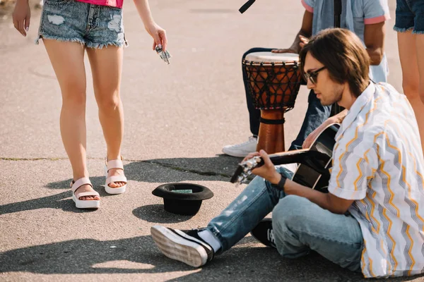 Jóvenes buskers felices tocando un concierto improvisado en la calle de la ciudad y recibiendo dinero - foto de stock