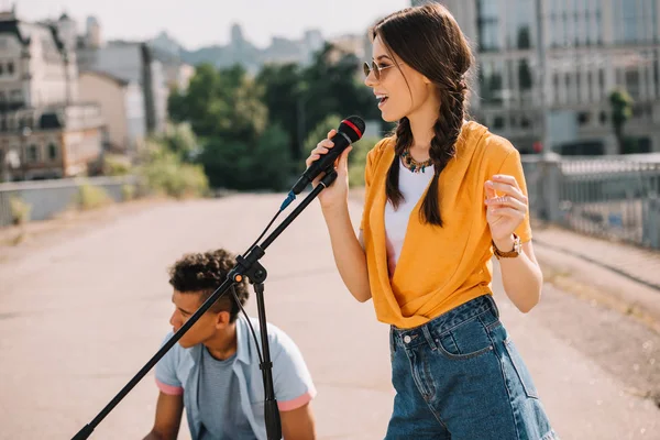 Jovens e felizes músicos de rua masculinos e femininos atuando na cidade — Fotografia de Stock