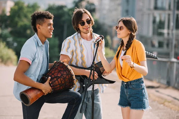 Young woman and multiracial men performing on sunny city street — Stock Photo