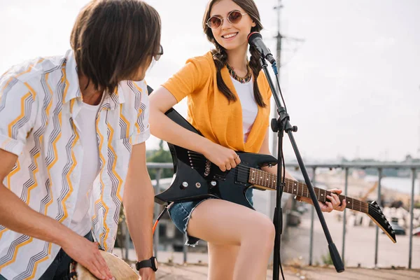 Молода і щаслива пара вуличних музикантів з гітарою і джембе в місті — стокове фото