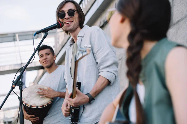 Jovens multirraciais felizes tocando e cantando na rua — Fotografia de Stock