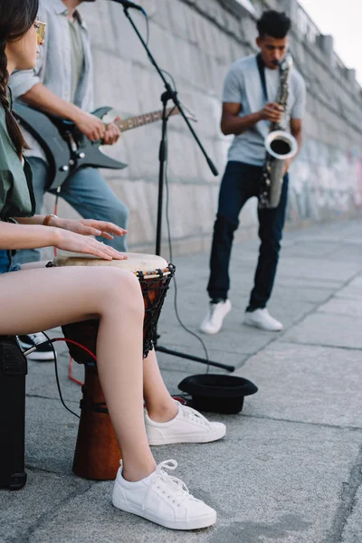 Talented street musicians with guitar, drum and saxophone performing in city — Stock Photo
