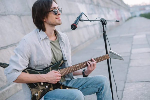 Молодий чоловік з гітарною імпровізацією під час виступу на вулиці — стокове фото