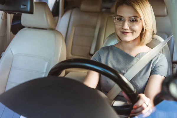 Attraente donna d'affari sorridente guida auto — Foto stock