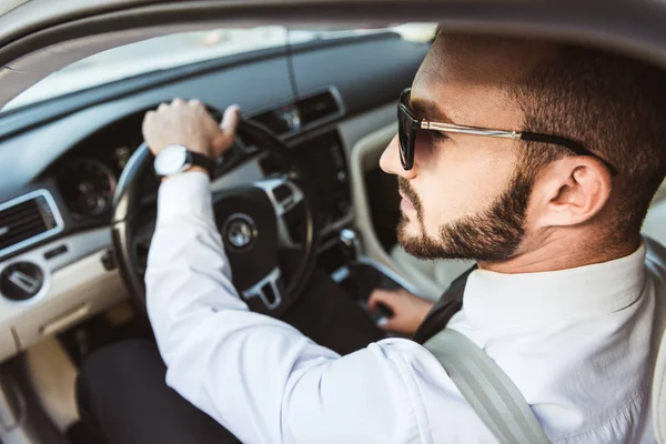 Beau conducteur en lunettes de soleil voiture de conduite — Photo de stock