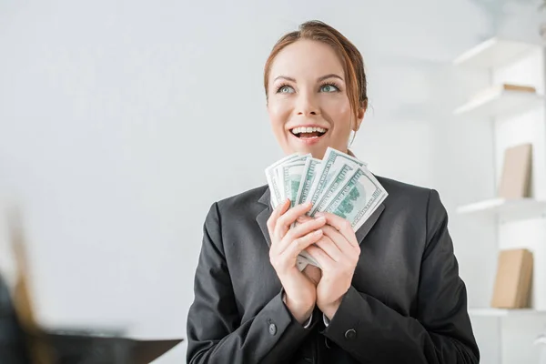 Happy financier holding dollar banknotes in office — Stock Photo