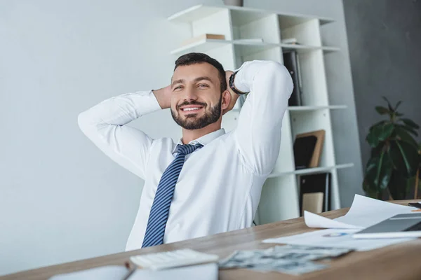 Щасливий бізнес радник відпочиває на стільці в офісі — стокове фото
