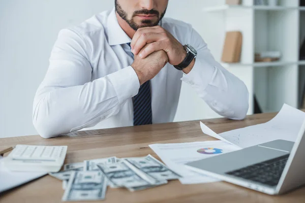 Обрезанный образ задумчивого финансиста, сидящего за столом в офисе — стоковое фото