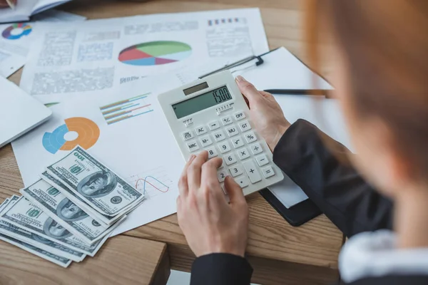 Обрезанное изображение финансиста с помощью калькулятора при работе в офисе — стоковое фото
