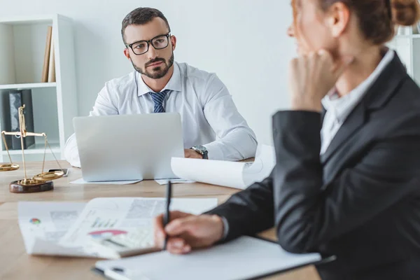 Financiers looking at each other at table in office — Stock Photo