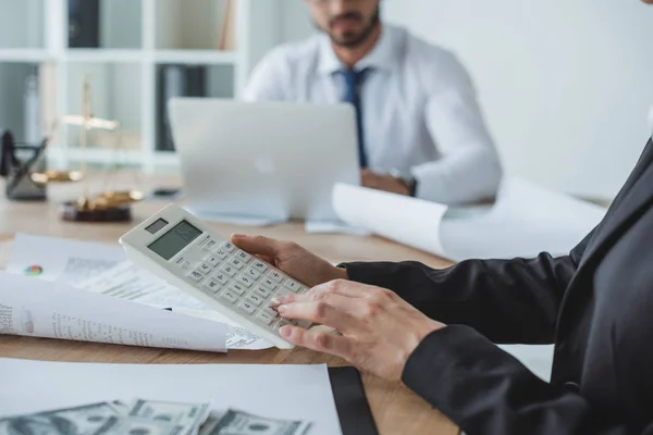 Обітнутого зображення фінансистів, використовуючи калькулятор і ноутбук в офісі — стокове фото