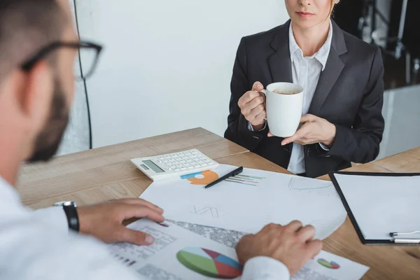 Abgeschnittenes Bild von Finanziers, die im Büro am Tisch sitzen — Stockfoto