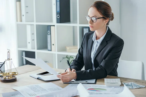Attractive financier working with documents at table in office — Stock Photo