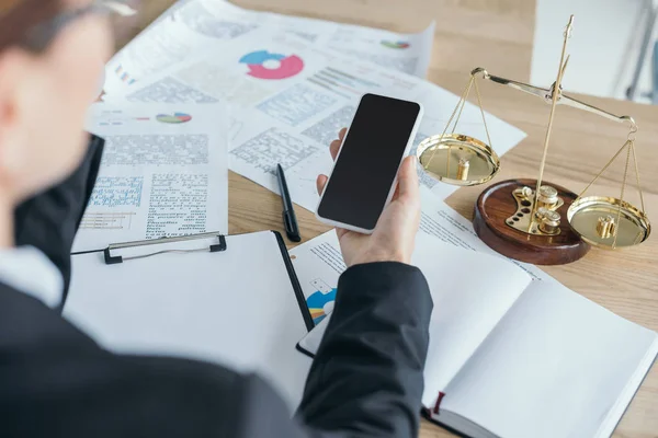 Cropped image of financier working at table in office and using smartphone — Stock Photo