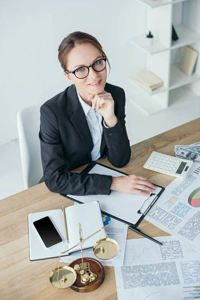 High angle view of financier working at table in office and looking at camera — Stock Photo