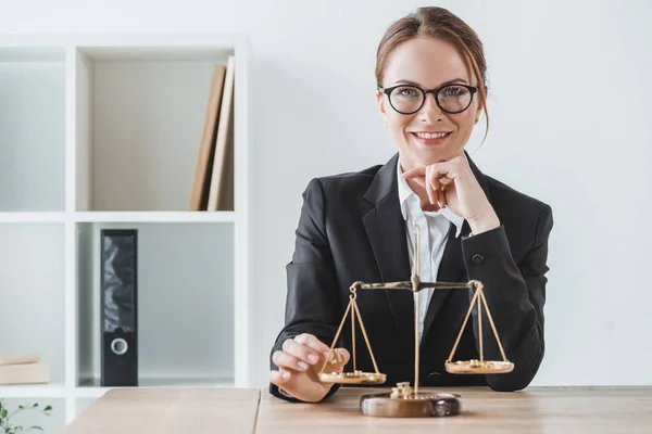 Lächelnder Unternehmensberater, der im Büro Präzisionsgewichte auf die Waage legt und in die Kamera blickt — Stockfoto