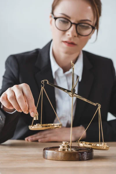 Business adviser putting precision weights on scales in office — Stock Photo