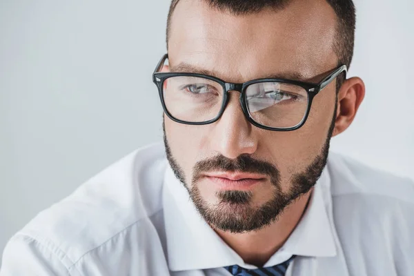 Porträt eines gutaussehenden Geschäftsmannes mit Brille, der isoliert von Weiß wegschaut — Stockfoto