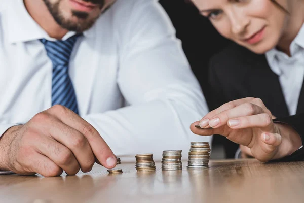 Cropped image of business advisers stacking coins on table in office — Stock Photo