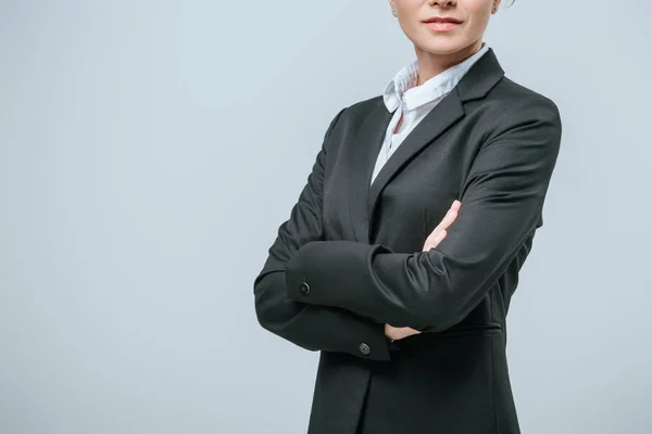 Cropped image of businesswoman standing with crossed arms isolated on grey — Stock Photo