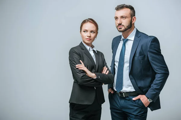 Серйозна бізнес-леді і бізнесмен дивиться ізольовано на сірий — стокове фото