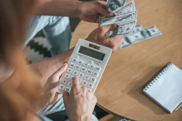Cropped image of couple planning family budget and calculating money in living room — Stock Photo