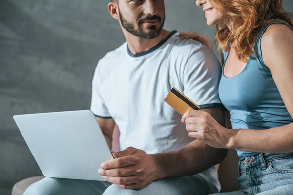 Cropped image of couple shopping online with laptop and credit card at home — Stock Photo