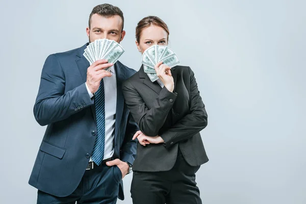 Financiers looking out from dollar banknotes and looking at camera isolated on grey — Stock Photo