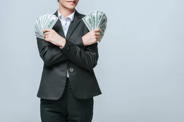 Imagen recortada de financista sosteniendo dólares en manos aisladas en gris - foto de stock