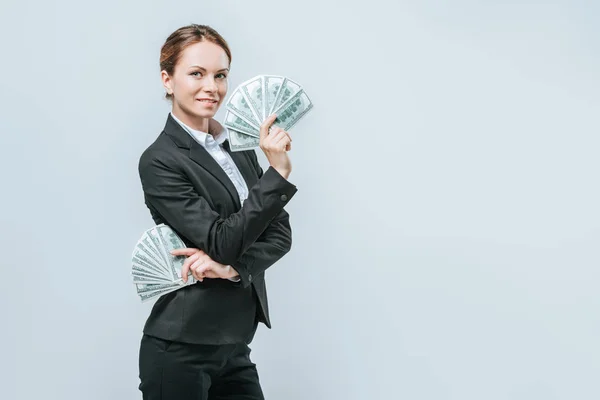 Sonriente financista atractivo posando con billetes de dólar aislados en gris - foto de stock