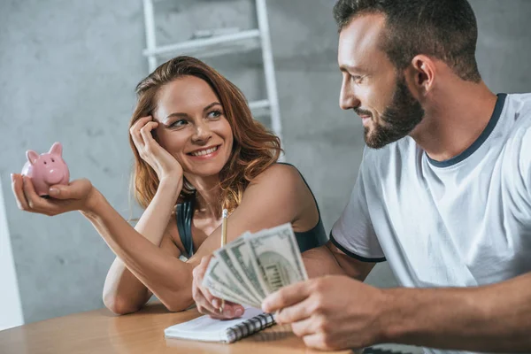 Feliz casal planejamento orçamento familiar e olhando uns para os outros na sala de estar — Fotografia de Stock